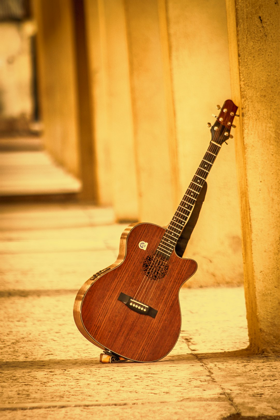 a-guitar-sitting-on-the-ground-next-to-a-wall-mq6qge7-cfg